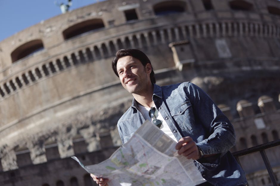 A young man holding a map smiles in front of Castle Sant'Angelo in Rome, Italy