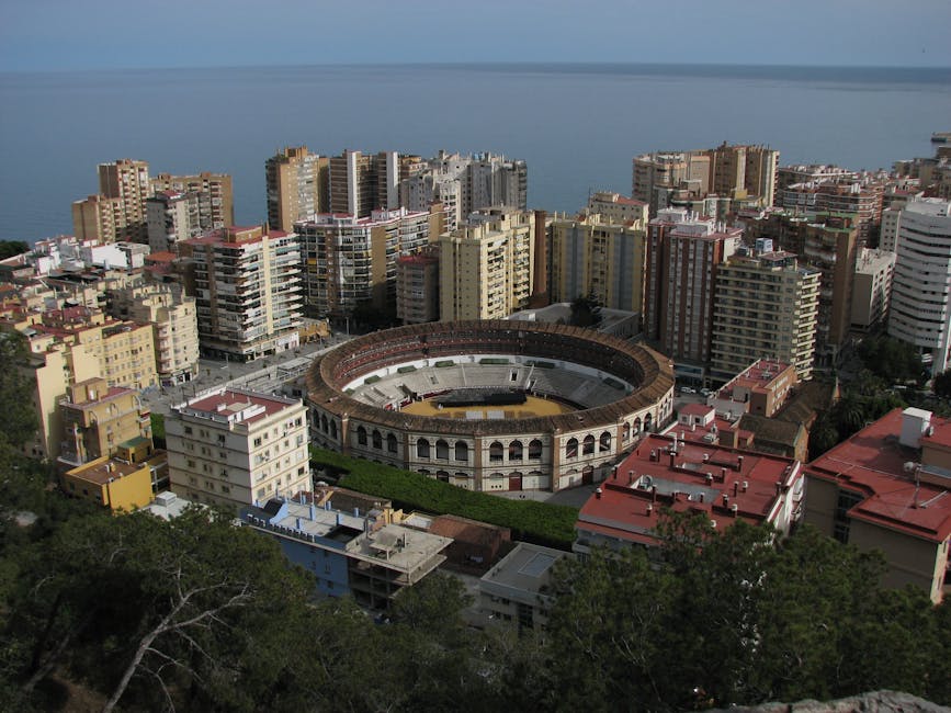 Aerial capture of Malaga's bullring surrounded by modern buildings and Mediterranean Sea