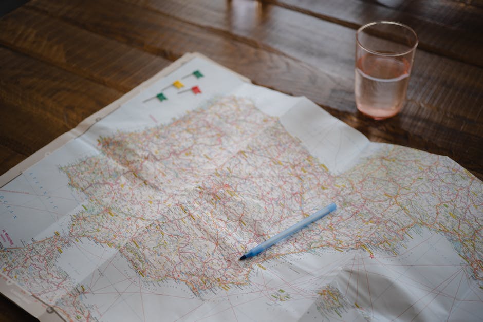 Map highlighting Spain and Portugal with a pen and glass on a wooden table