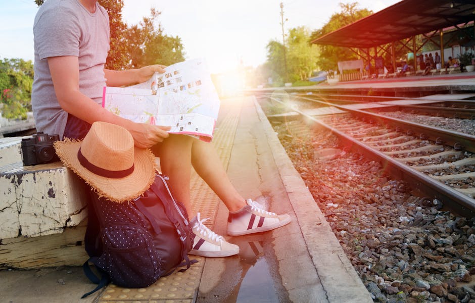 Person sitting at train station platform reading map