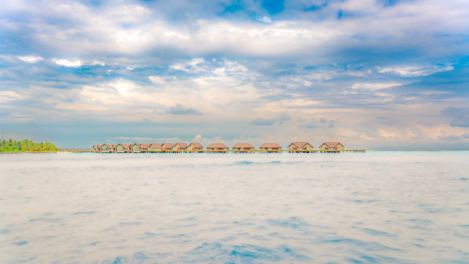 Idyllic overwater bungalows on a calm ocean with a vibrant sky in Maldives