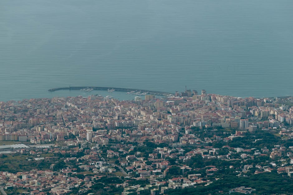 Explore the stunning aerial view of Naples, Italy, with its sprawling cityscape and serene coastline